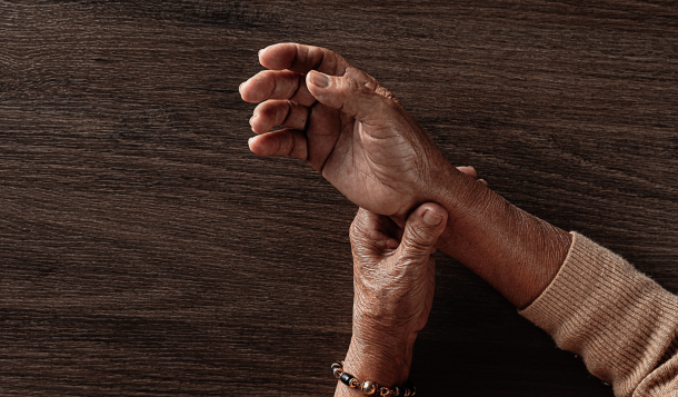 Main d'une personne atteinte de la maladie de Parkinson illustrant les symptômes et le besoin d'un accompagnement à domicile.